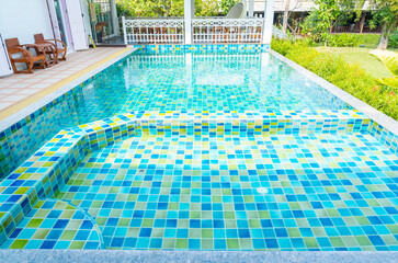 The Macro from Swimming pool with clear blue water in a garden area, surrounded by plants