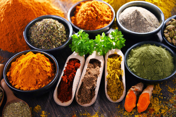 Variety of spices on wooden kitchen table.