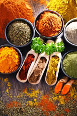 Variety of spices on wooden kitchen table.