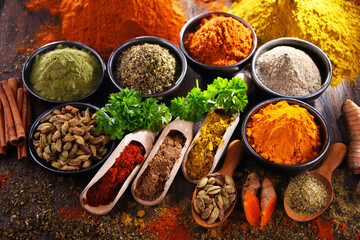 Variety of spices on wooden kitchen table.
