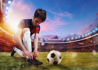 Soccer player ties his football shoes ready to play at the stadium