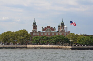 Ellis Island building and United States flag with water in New York