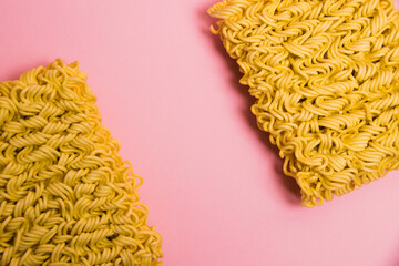 Flatlay, paper background with copy space. Two large servings of instant noodles on a pink background.