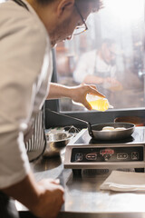 Сooking food, profession and people concept - male chef cook with frying pan at restaurant kitchen..