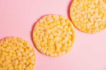Flatlay, crispy, diet cornbread on a pink background.