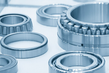 The cylindrical rolling bearing parts in light blue scene. - obrazy, fototapety, plakaty