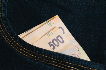Ukrainian money in the pocket of dark jeans.