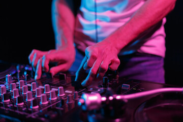 DJ playing music on party in nightclub. Disc jockey mixing records in the club