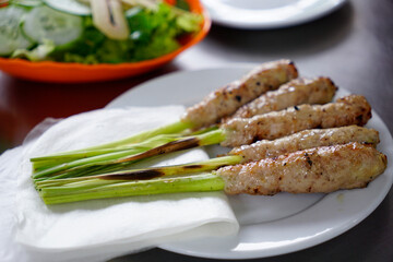 Hue specialty grilled fermented pork roll on a plate with rice paper