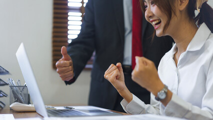 Financial business concept, Senior business and employee look on laptop and raise arms to celebrate