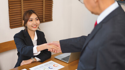 Business analysis concept, Businesswoman and senior business shaking hand after deal work together