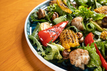 Tasty grilled vegetables red pepper, mushrooms, zucchini, corn, salad.