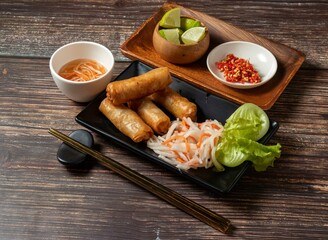 Fried spring rolls with lime and noodles served in bowl isolated on table top view of taiwan food