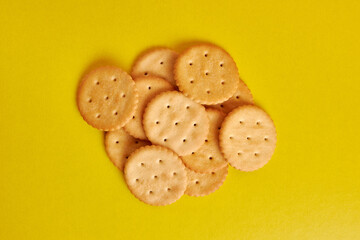A pile of round cookies on a yellow background. A tasty and sweet snack.
