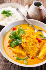 Traditional Thai fish curry with fish, vegetable and rice in spicy sauce served as close-up in design bowl
