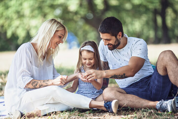 Happy family with beautiful daughter enjoying in nature