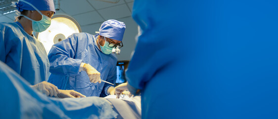 Group of surgeons doing surgery in hospital with reflection in glasses.Team of professional...