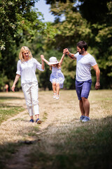 A happy family enjoying nature and having fun with their daughter