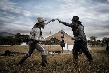 photographer in action. two cowboy fighting on the grass. vintage images of cowboys, two people who are fighting with knife.
