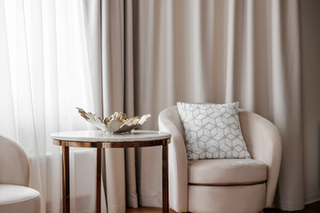 Abstract gold vase on the table in the interior of the house. Luxury bedroom in a house with modern interior design, coffee table, gold decor. 