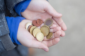 Few coins in the hands of the child. The problem of poverty in Europe.