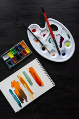 set of tools,  watercolor on black table surface, artist tools