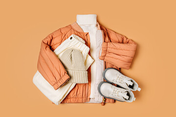 Stylish terracotta children's autumn jacket with knitted sweater, trousers and boots. Fashion kids...