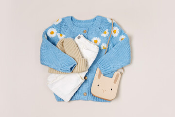 Cute blue knitted children's jacket with trousers, hat and bag. Stylish kids clothes for spring,...