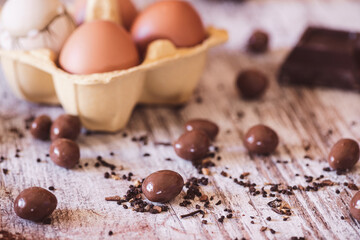 Chocolate covered almonds and eggs in the background