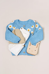 Cute blue knitted children's jacket with trousers, hat and bag. Stylish kids clothes for spring, autumn or winter. Fashion outfit. Flat lay, top view