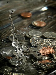 Coins dropping into the water