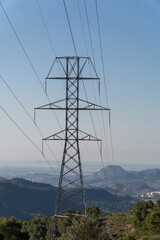 Obraz premium High voltage pylons on a sunny morning with blue sky.