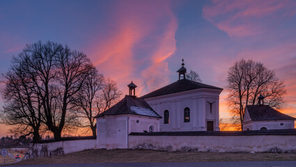 Fototapeta na wymiar Winter sunset with color sky near Andelska Hora village with ruins and chapel
