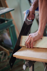 Carpenter using working tools while working on a wood in carpentry workshop