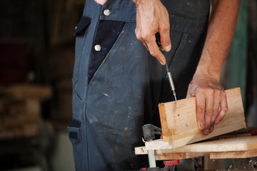 Carpenter using working tools while working on a wood in carpentry workshop