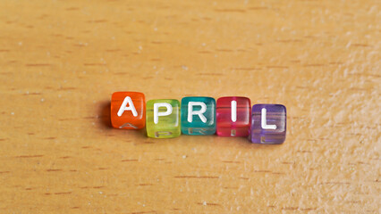 "April" word in colorful cubes. concept of months of the year, time. fun concept of time for kids