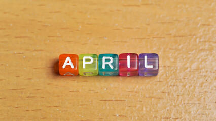 "April" word in colorful cubes. concept of months of the year, time. fun concept of time for kids