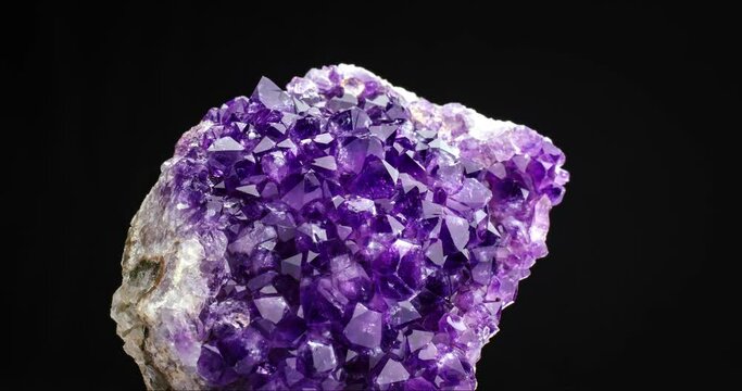 Amethyst geode crystal seamless rotating on black background. macro detail texture background. close-up raw rough unpolished semi-precious gemstone