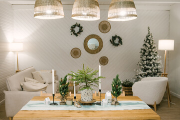 Interior of a beautiful light house decorated for New, white sofa, armchair and Christmas table