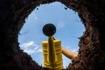 View of watering cans from freshly dug pits in the garden View from below.