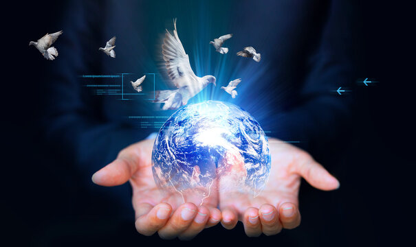 Businessman holding Earth globe with flying pigeons. Elements of this image are furnished by NASA
