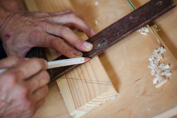 Carpenter using working tools while working on a wood in carpentry workshop