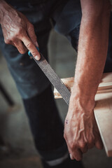 Carpenter using working tools while working on a wood in carpentry workshop