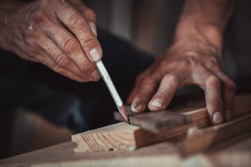 Carpenter using working tools while working on a wood in carpentry workshop