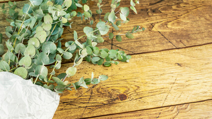 Bouquet with eucalyptus branches on wooden background. Eco friendly holiday composition with...
