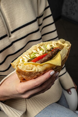 Woman hands holds doner kebab. Fast food take away. copy space