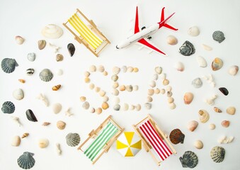 Fototapeta na wymiar Beach composition on the seashore, bright sun lounger, yellow umbrella, tourist plane, seashells. The concept of rest in warm countries, travel. Flat lay, top view.
