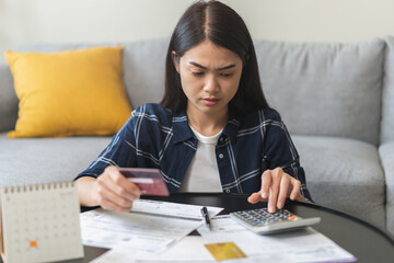 Business financial concept, stressed asian young business woman using calculator for calculate...