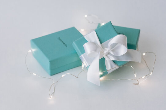 Two brand boxes and one with a white silk ribbon.