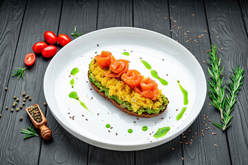 Scramble on toast with salmon and guacamole and olives